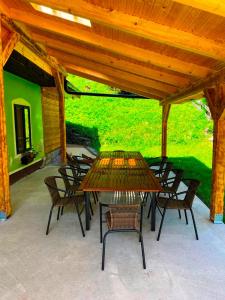 a patio with a table and chairs under a wooden roof at Horská chata Stará Horáreň 1 in Dobšiná