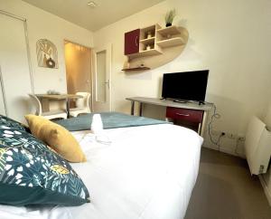 Schlafzimmer mit einem Bett und einem Schreibtisch mit einem Computer in der Unterkunft Neoresid - Résidence Republique in Douai