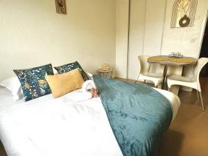 Bett in einem Zimmer mit einem Tisch und einem Tisch in der Unterkunft Neoresid - Résidence Republique in Douai
