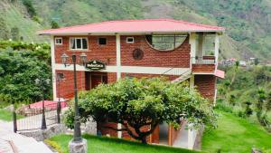 dom z czerwonej cegły z napisem w obiekcie Habitación privada con terraza panorámica, cocina, parqueadero w Baños
