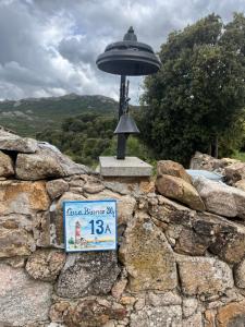 a sign on a stone wall with a street light at Stazzo Casa Bianco Fly in Aggius +44 photos