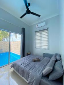 Schlafzimmer mit einem Bett und einem Deckenventilator in der Unterkunft Homestay Sekinchan with Private Pool in Sekinchan