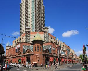 a large brick building with tall buildings in the background at Vintage Charm Oasis - CBD Living with Parking in Sydney