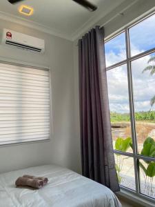 ein Schlafzimmer mit einem Bett und einem großen Fenster in der Unterkunft Homestay Sekinchan with Private Pool in Sekinchan