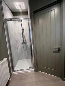 uma casa de banho com um chuveiro e uma porta de vidro em Luxury Lodge With Hot Tub In Royal Deeside em Strachan
