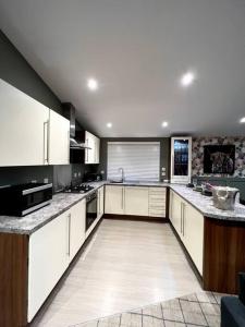 a kitchen with white cabinets and granite counter tops at Luxury Lodge With Hot Tub In Royal Deeside in Strachan