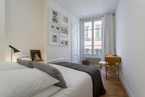 1 dormitorio con cama, escritorio y ventana en Curiosité - 2 chambres- proche Opéra, en Lyon