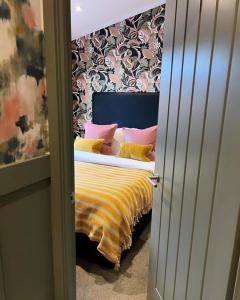 um quarto com uma cama com almofadas amarelas e rosas em Luxury Lodge With Hot Tub In Royal Deeside em Strachan