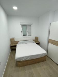 a white room with a bed and a window at Habitación en Planta Baja con terraza in Barcelona
