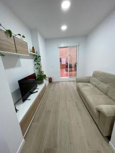 a living room with a couch and a tv at Habitación en Planta Baja con terraza in Barcelona