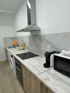 a kitchen with a stove top oven next to a microwave at Habitación en Planta Baja con terraza in Barcelona