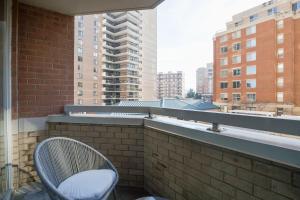 una silla en el balcón con vistas a los edificios en Apartment Just Steps from Ballston Subway Station, en Arlington