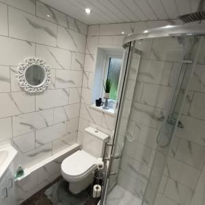 y baño blanco con aseo y ducha. en Le Hub - Roundhay Leeds - 1-Bed Studio Apartment, en Leeds