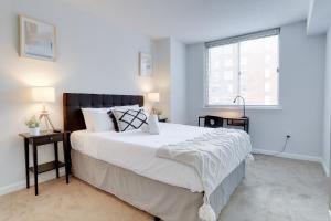 Un dormitorio con una gran cama blanca y una ventana en Apartment Just Steps from Ballston Subway Station, en Arlington