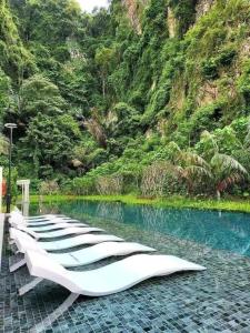 a row of loungers sitting next to a pool of water at IPOH TAMBUN THE COVE Your Ultimate Relaxation Getaway777 in Ipoh
