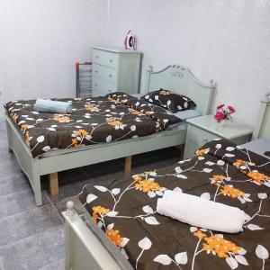 two beds in a bedroom with two bedsskirts at العين الهيلي مصباح ب 2 in Al Ain