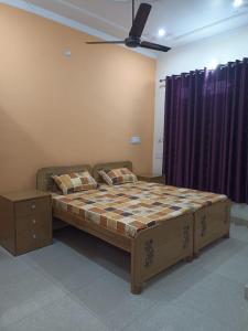 a bedroom with a bed and a ceiling fan at Anant Paying Guest house in Ayodhya