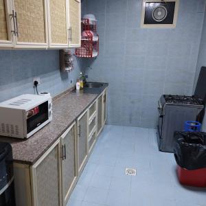 a kitchen with a microwave and a stove at العين الهيلي مصباح ب 2 in Al Ain