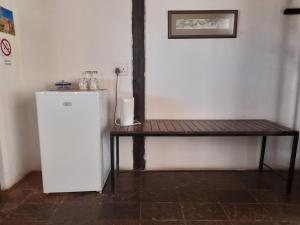 a small white refrigerator sitting next to a wooden table at Lion's Den Guesthouse Otjiwarongo in Otjiwarongo