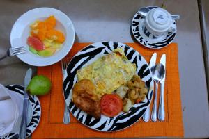 a plate of food on a table with a bowl of fruit at Hotel Moon Residency Near Yashobhoomi Convention Centre in New Delhi