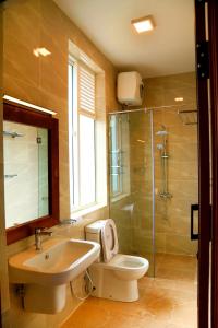 La salle de bains est pourvue de toilettes, d'un lavabo et d'une douche. dans l'établissement Square One Heights - Kelaniya, à Kiribathgoda