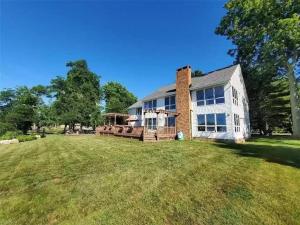 an image of a house with a large yard at Lakeside resort home. Sunsets, fishing, paddling. in Avon Lake