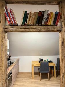 une chambre avec une table et une étagère avec des livres dans l'établissement Gemütliches Apartment mit Arbeitsplatz, Smart-TV, WLAN in Hamm Mark, à Hamm