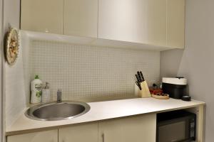 um balcão de cozinha com um lavatório e um micro-ondas em Vintage Charm Oasis - CBD Living with Parking em Sydney