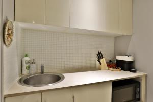 a kitchen counter with a sink and a microwave at Vintage Charm Oasis - CBD Living with Parking in Sydney