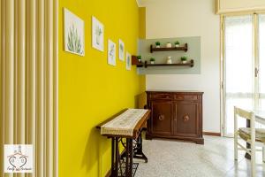 Habitación con mesa y pared amarilla en FamilyBO Apartments Murri - Self Check-in, en Bolonia