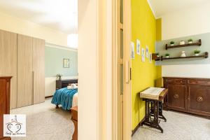 1 dormitorio con paredes amarillas, 1 cama y escritorio en FamilyBO Apartments Murri - Self Check-in, en Bolonia