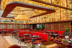 a restaurant with red chairs and tables and lights at Taj Dubai in Dubai