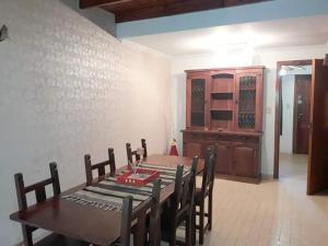 a dining room with a table and chairs and a cabinet at Triplex a dos cuadras del mar in Necochea