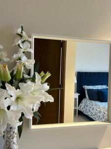 un jarrón de flores blancas delante de un espejo en Sifah Ocean Breeze Villa en Mascate