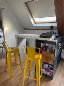 2 gele stoelen en een bureau in een kamer bij Chambre meublé idéale pour déplacement d'affaires in Le Petit-Quevilly