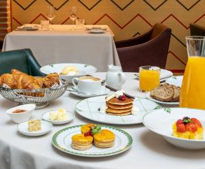 einen Tisch mit Speisen zum Frühstück und Orangensaft in der Unterkunft Palacio Solecio, a Small Luxury Hotel of the World in Málaga
