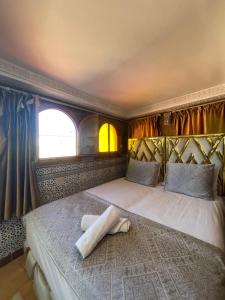 a bedroom with a bed with a pillow on it at Riad Malak in Meknès