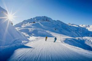 two people are skiing down a snow covered mountain at Superbe appartement au centre de la station in Nendaz