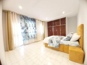 a bedroom with a bed and a large window at Villa KELIA Biyem-Assi Acacias in Yaoundé