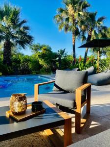 a couch sitting on a table next to a pool at Le Cocoon Lodge du Gapeau & Massage in Solliès-Pont