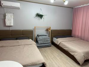 a bedroom with two beds and a mirror at Sacheon Songlim in Gangneung