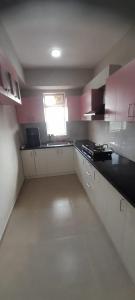 a kitchen with pink and white cabinets and a window at Nanma East Fort in Mūvattupula