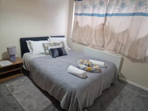 1 dormitorio con 1 cama con toallas y ventana en The Pride of Manchester, Trafford, en Mánchester