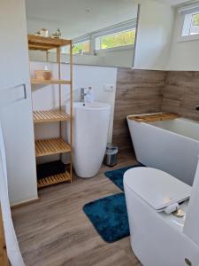 a bathroom with a tub and a toilet and a sink at Chalet in Ursel in Aalter