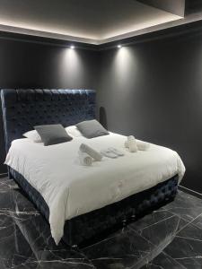 a large bed with white sheets and pillows on it at La Suite Prestige Jacuzzi,Sauna,Netflix,Disney in Amiens