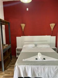 um quarto com uma cama com uma parede vermelha em Casa da Lagoa em Jijoca de Jericoacoara