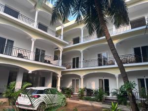 un coche blanco estacionado frente a un edificio en Morjim Sunset Guesthouse- Apartments with Kitchen, en Morjim