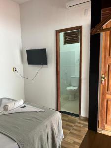 a room with a bed and a bathroom with a toilet at Casa da Lagoa in Jijoca de Jericoacoara