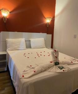 a bed with a white blanket with hearts on it at Casa da Lagoa in Jijoca de Jericoacoara