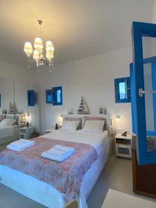 a bedroom with a large white bed with blue accents at Villa on the beach, Sarpakis Villa in Tzamaria